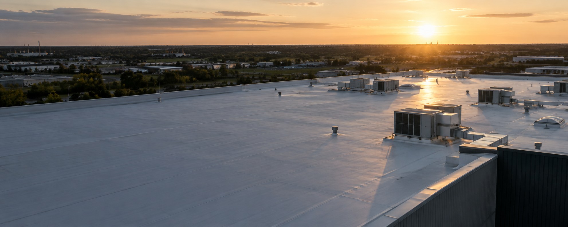 Aerial view of a large commercial flat roof at sunset