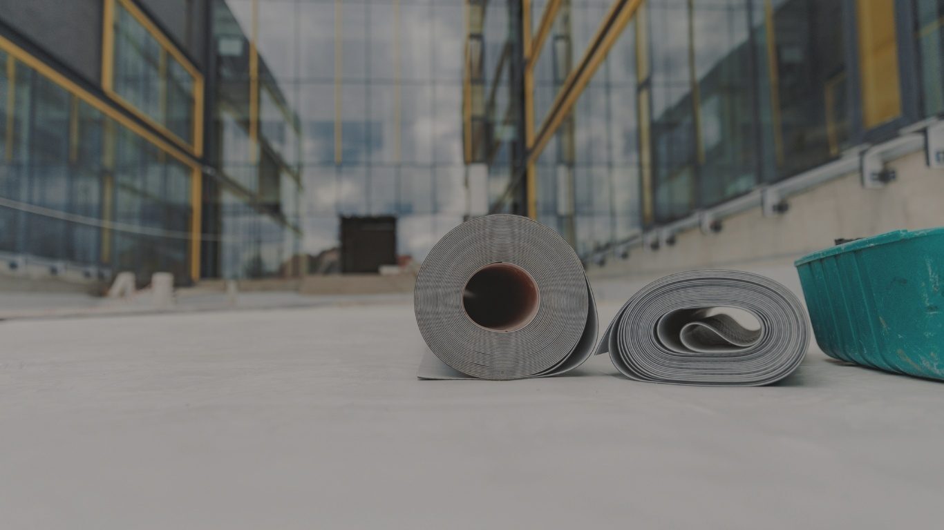 Rolls of EPDM roofing membrane on a commercial roof.
