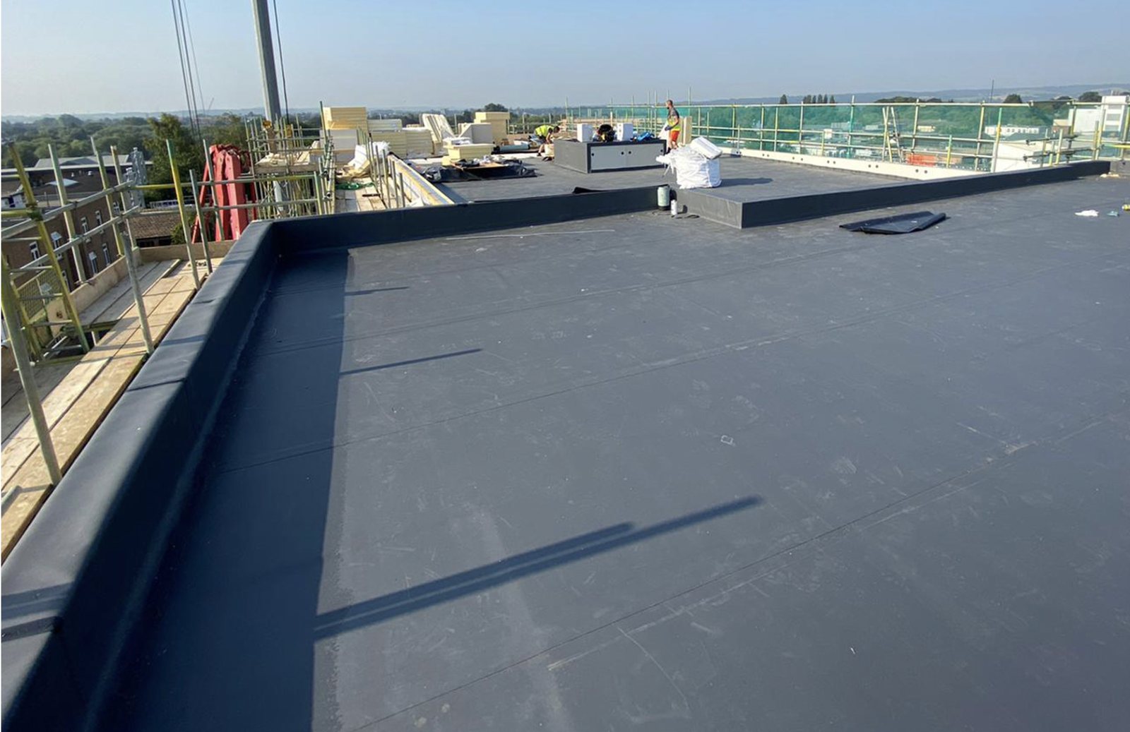 Dark single-ply membrane installed across a commercial flat roof.