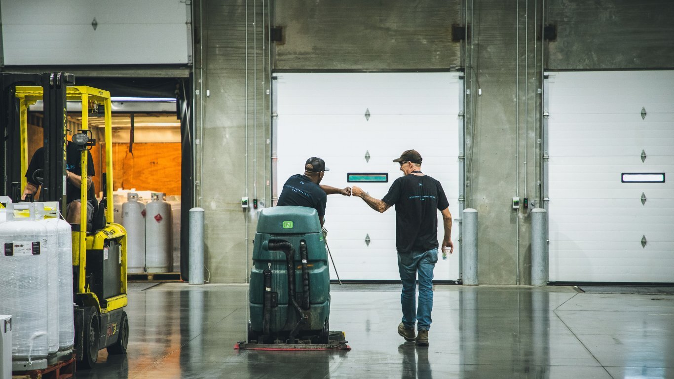 Two Quin Global coworkers bumping fists on the warehouse floor