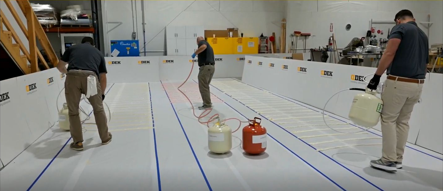 Three applicators running side-by-side adhesive bead lanes during QDEK's timed 63-foot test.